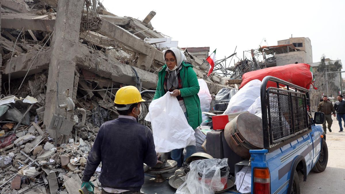 Los iraníes recogen sus pertenencias entre los escombros de sus edificios residenciales dañados en el centro de Teherán.