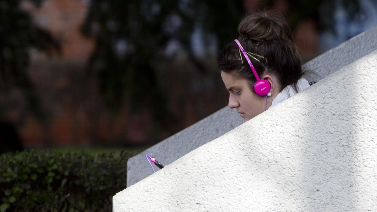 Una chica escucha música en su móvil