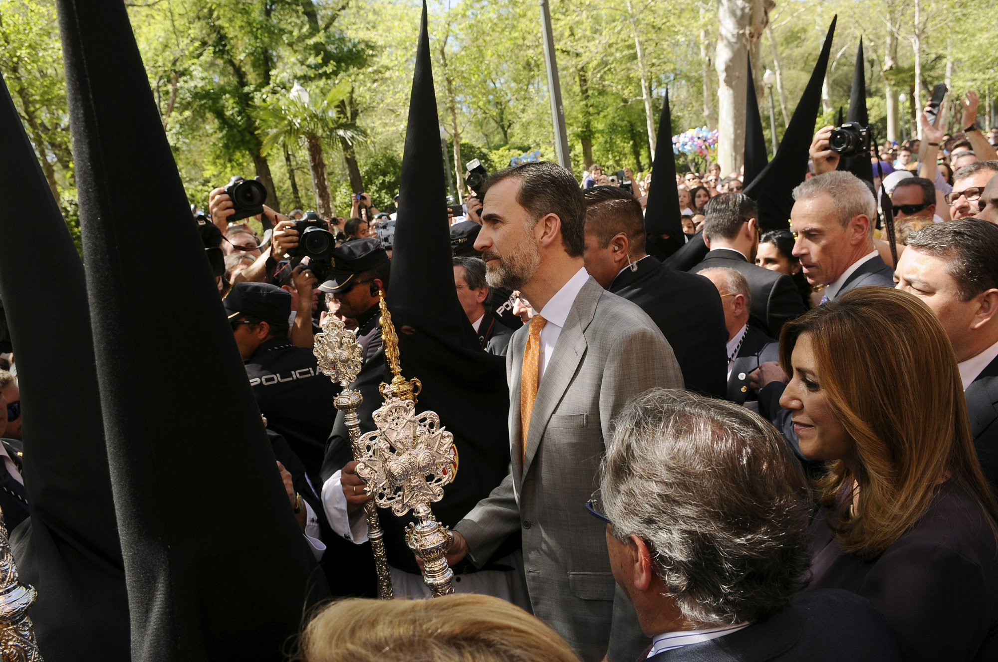 ESPAÑA REY SEMANA SANTA:GRA226. SEVILLA 30/03/2015.- El Rey Felipe VI (c), acompañado por la presidenta andaluza, Susana Díaz (d), entre los Nazarenos de la Hermandad de Santa Genoveva en su recorrido por el Parque de María Luisa en Sevilla, momentos antes de dar el golpe de llamador del paso de palio de esta cofradía del Lunes Santo. EFE/Raúl Caro