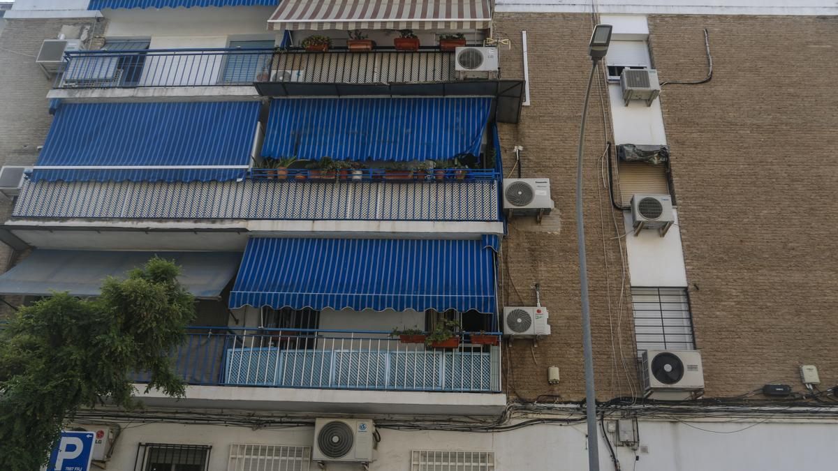 Fachada de edificio con aires acondicionados y toldos.