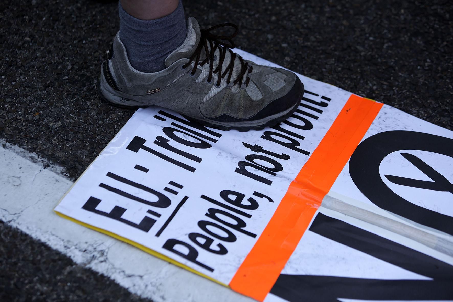 Un manifestante pisa la palabra troika en un cartel