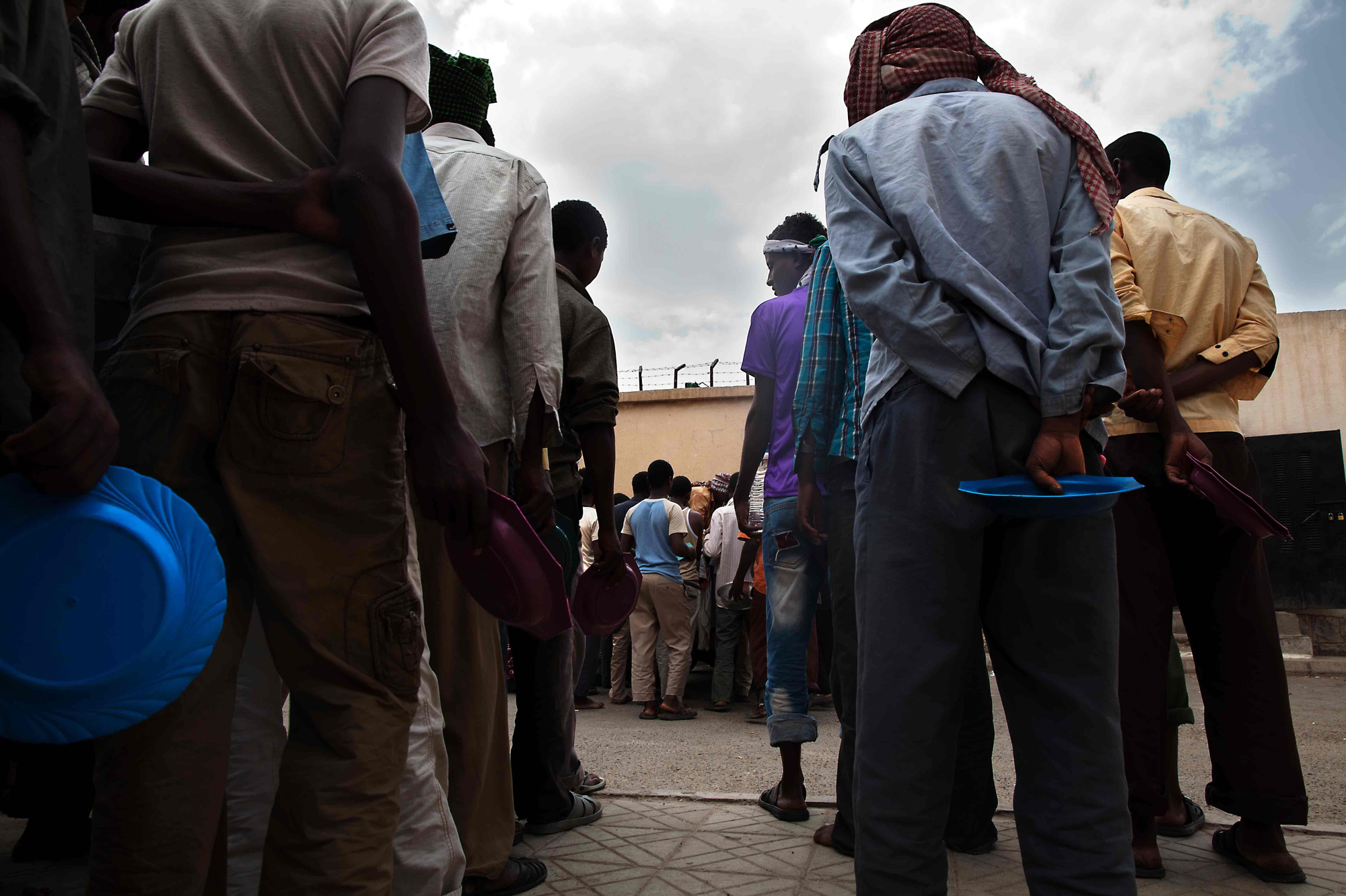 Largas filas a la espera de que rellenen sus platos de comida/ Copyright: Anna Surinyach/MSF