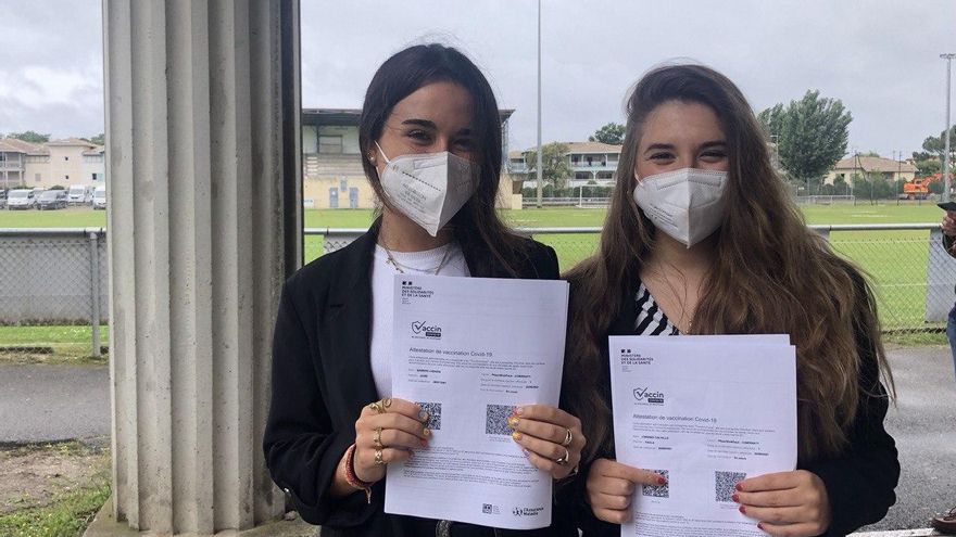 Leire Barros y Paola Lorenzo con el certificado que acredita que han recibido la primera dosis de la vacuna contra la COVID-19