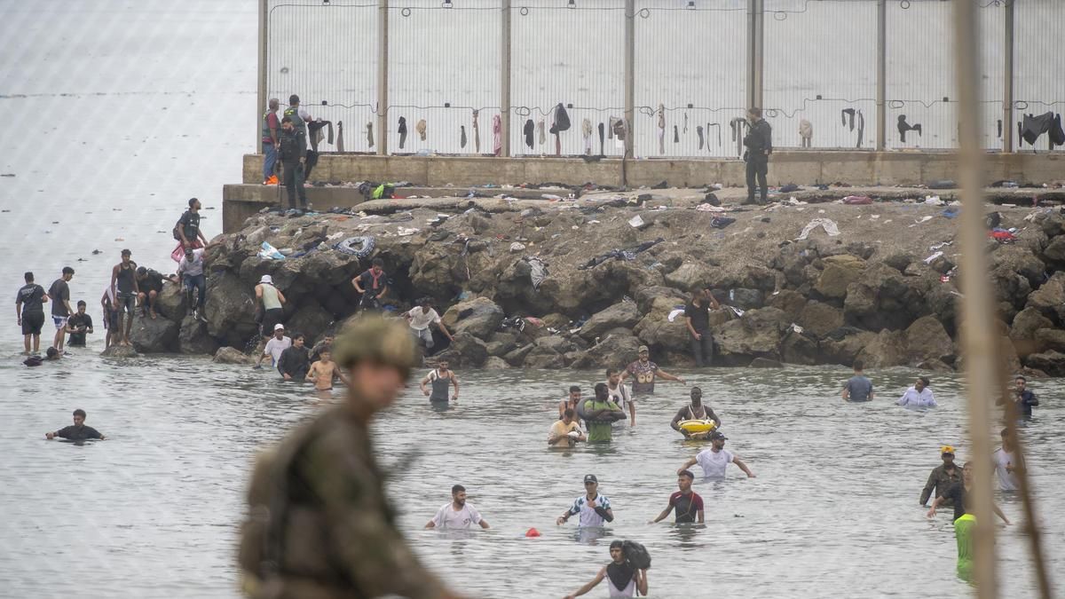 Decenas de personas intentando cruzar la frontera, a 31 de julio de 2026, en Ceuta.