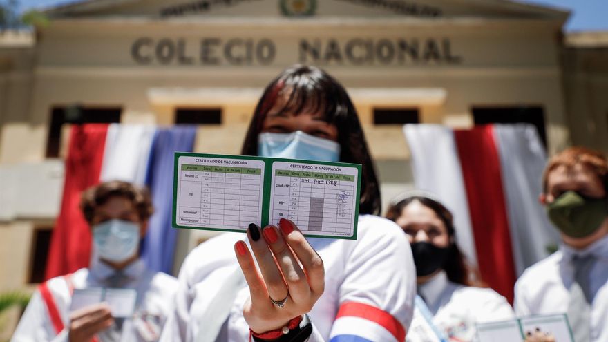 Alumnas y alumnos del Colegio Nacional de la Capital (CNC) muestran su carnet de vacunación contra la Covid-19 en Paraguay