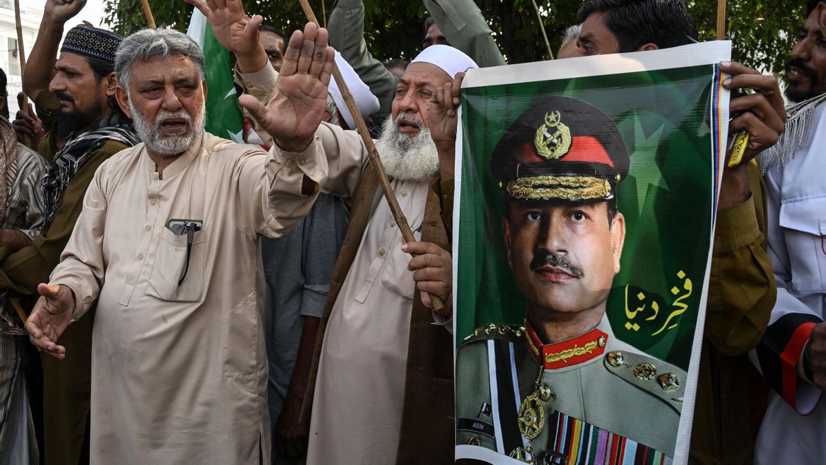 Conductores del sindicato de bicitaxis Awami muestran pósteres con la imagen del jefe del Estado Mayor del Ejército de Pakistán, Asim Munir, mientras celebran en Islamabad el alto el fuego entre EEUU e Irán.