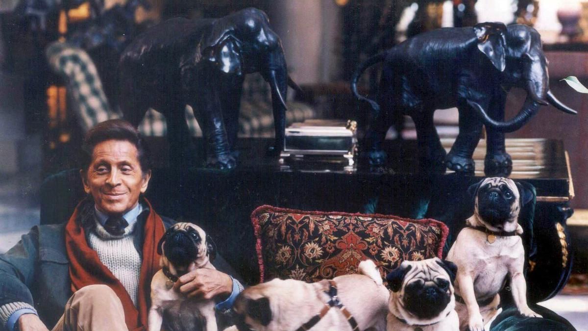 Fotografía de archivo sin fecha del diseñador italiano Valentino Garavani jugando con sus perros en su taller del centro de Roma, Italia