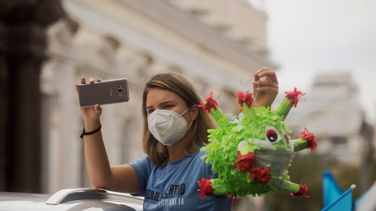 Una mujer sostiene una piñata del coronavirus. EFE/ Esteban Biba/ Archivo