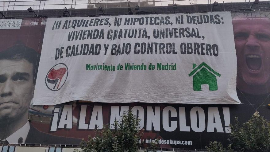 Activistas antidesahucios tapan la lona de Desokupa con lemas por el derecho a la vivienda
