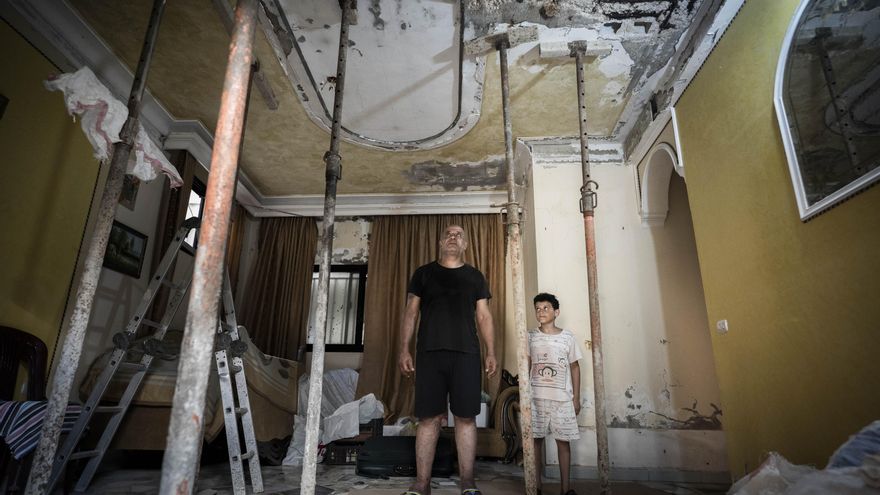 Yasser Abed Al-Halim observa con su hijo el techo de su casa, dañado tras la onda expansiva de la explosión de agosto de 2020 en el puerto de Beirut, en el campo de personas refugiadas palestinas de Burj El Barajneh (Beirut).