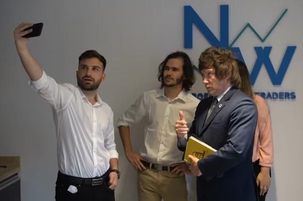 Javier Milei hace su tradicional gesto ante la selfie tomada por Mauricio Novelli, su contratante, antes de que ambos pusieran un pie en Casa Rosada.