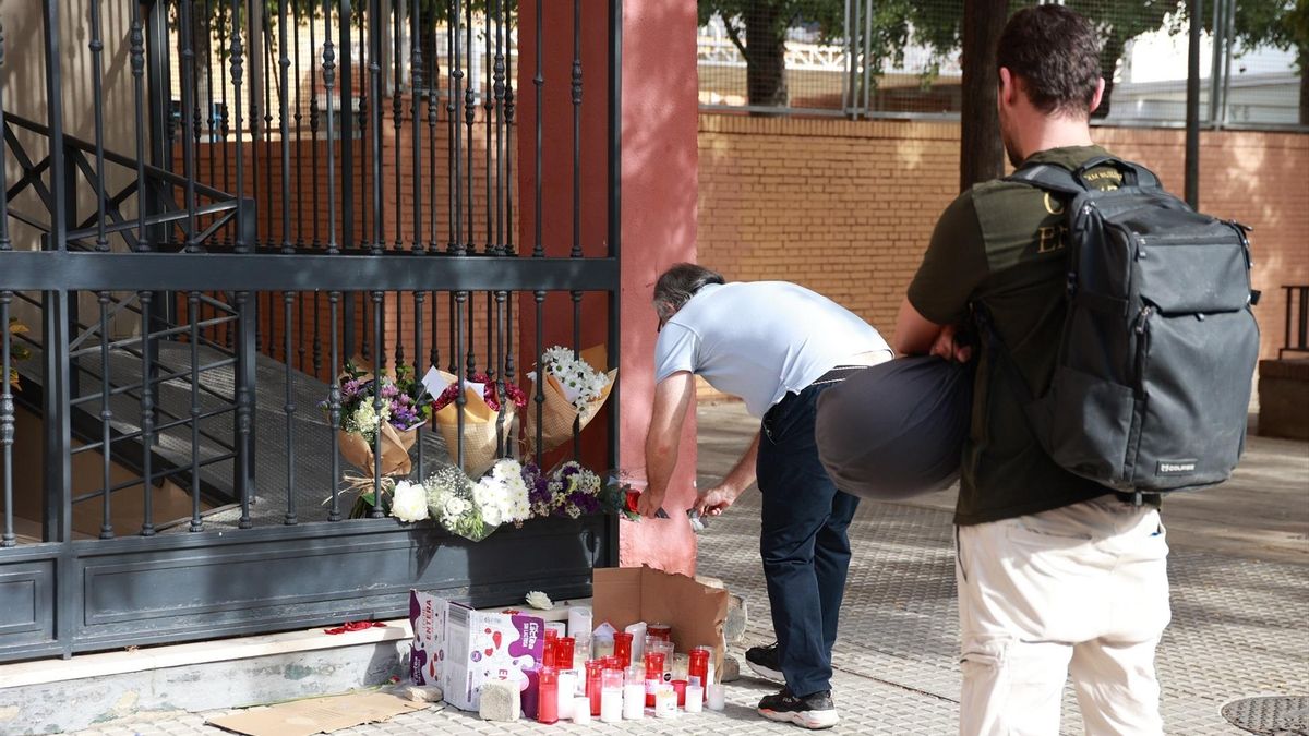 Flores y velas recuerdan a Sandra Peña en la puerta del bloque en el que vivía.