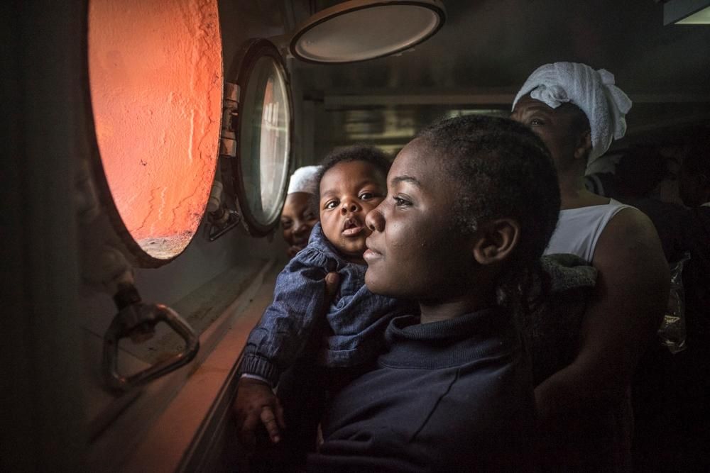Una mujer y su bebé miran por la ventana antes de atracar a tierra. En 2016, más de 180.000 personas llegaron a Italia tras jugarse la vida en el Mediterráneo central. Una de cada 9 fueron rescatadas por los equipos de MSF en del Dignity I, el Bourbon Argos y el Aquarius. No obstante, más de 4.600 personas han fallecido en el intento en esta ruta mortal. © yann Merlin/SOS MEDITERRANEE