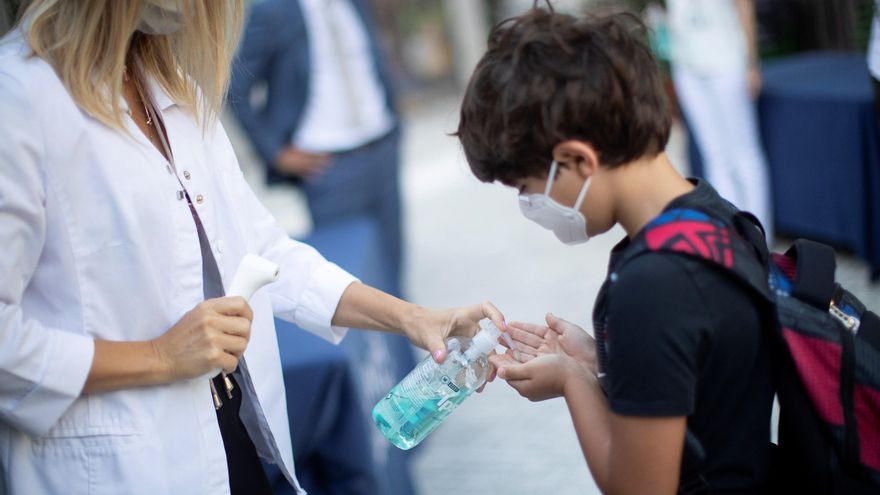 Un niño se desinfecta las manos después de que le tomen la temperatura a la entrada de un colegio de Barcelona. EFE/ Marta Perez/Archivo