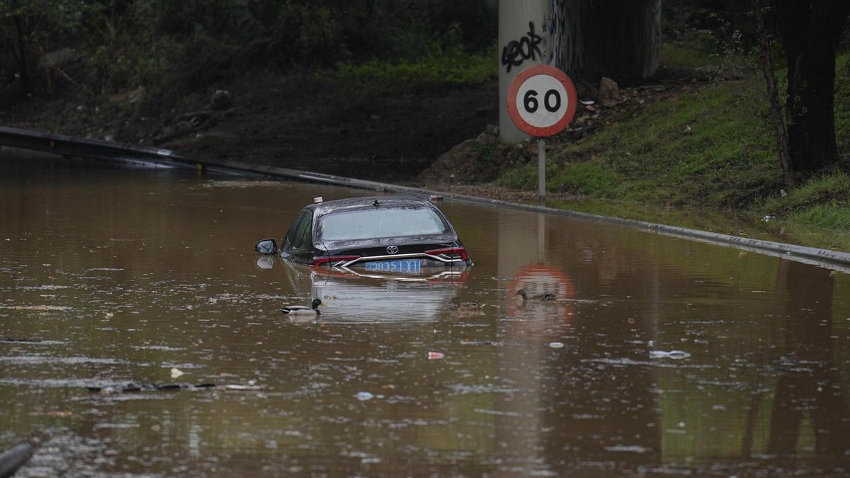 Vista de un vehículo anegado en lo accesos a la ronda del Litoral, en Badalona este domingo, cuando el río Besòs arrastra a primera hora un caudal de 903 metros cúbicos por segundo, con una altura de 3,5 metros, a su paso por Santa Coloma de Gramanet (Barcelona), lo que ha llevado a la Agencia Catalana del Agua a lanzar un aviso por riesgo de inundaciones en la zona.