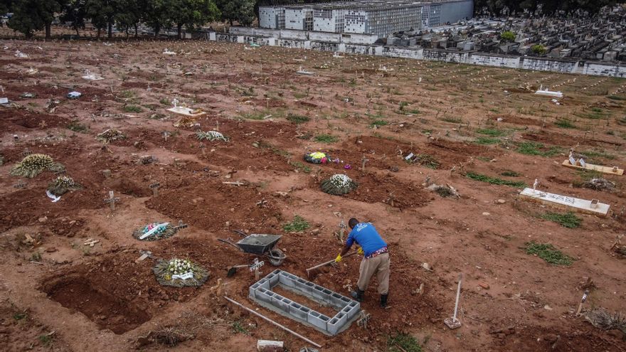 Fotografía tomada con dron que muestra a un sepulturero mientras cava nuevas tumbas para víctimas covid-19 hoy, en un cementerio del norte de Río de Janeiro (Brasil). EFE/ André Coelho