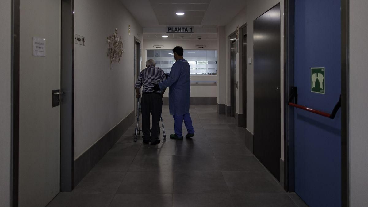 Un trabajador atiende a un anciano en una residencia de mayores