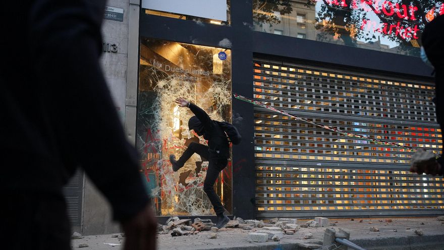 Un manifestante rompe un escaparate de Carrefour en Barcelona