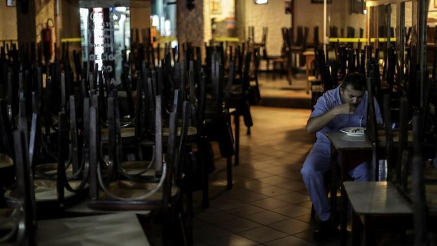 Un empleado del Café Lamas se alimenta en la sede del café, el 12 de mayo de 2020, en Río de Janeiro (Brasil). En sus 146 años de vida, el Café Lamas solo cerró sus puertas en dos ocasiones: durante la revolución de las vacunas (1904) y luego del suicidio del presidente Getulio Vargas -en agosto de 1954-, uno de sus clientes más fieles.