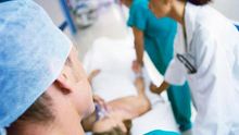 Un grupo de médicos, junto a la camilla de un paciente.