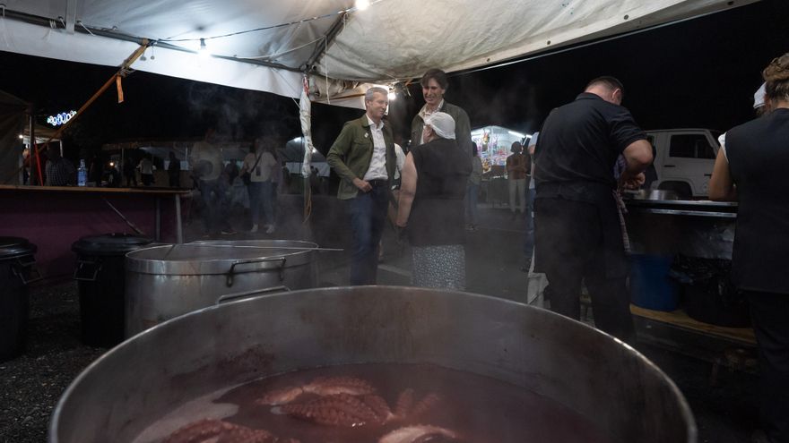 Alfonso Rueda (a la izquierda) charla con una pulpeira en una fiesta en Vedra (A Coruña).