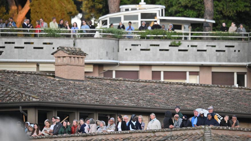 Grupos de curiosos se acumulan en los tejados de la plaza de San Pedro esperando la fumata