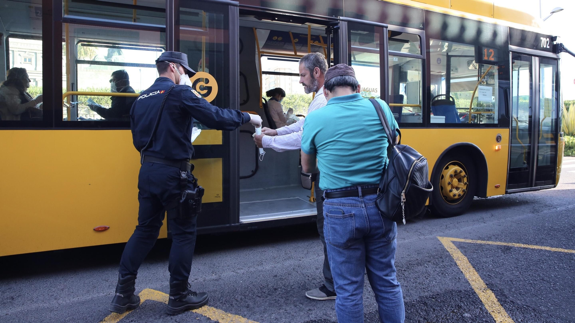 La Policía entrega mascarillas a pasajeros de guaguas. (Alejandro Ramos)