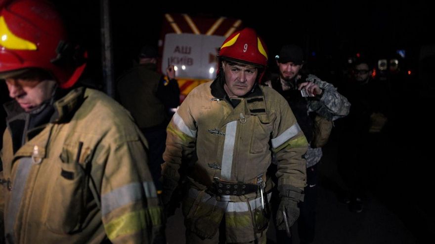 Un equipo de bomberos atiende la zona afectada por los bombardeos de este jueves cerca del centro de Kiev (Ucrania), en el barrio de Shevchenkovsky.