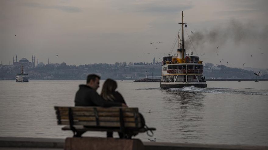 Istanbul (Turkey), 07/02/2021.- People sit near the Bosphorus in front of the Hagia Sophia Grand Mosque during the lockdown in Istanbul, Turkey, 07 February 2021. Turkey imposed coronaviurs measures to halt the spread of coronavirus. (Turquía, Estanbul)