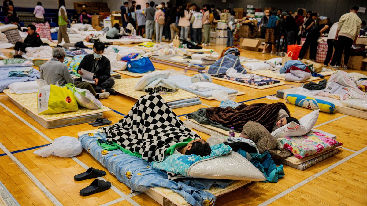 Las personas afectadas por el incendio en el distrito de Tai Po descansan en un refugio de emergencia en Hong Kong.