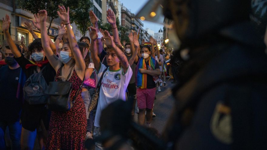 Miles de manifestantes marchan con las manos en alto ante la mirada de agente de la Policía.