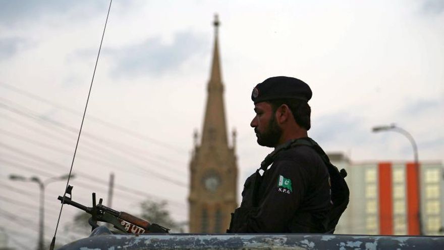 Un policía monta guardia en un punto de control en Pakistán..