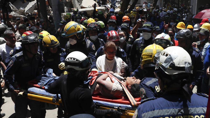 Integrantes del cuerpo de Bomberos de Cali rescatan a una mujer de entre los escombros en Torres del Limonar, en Cali (Colombia).