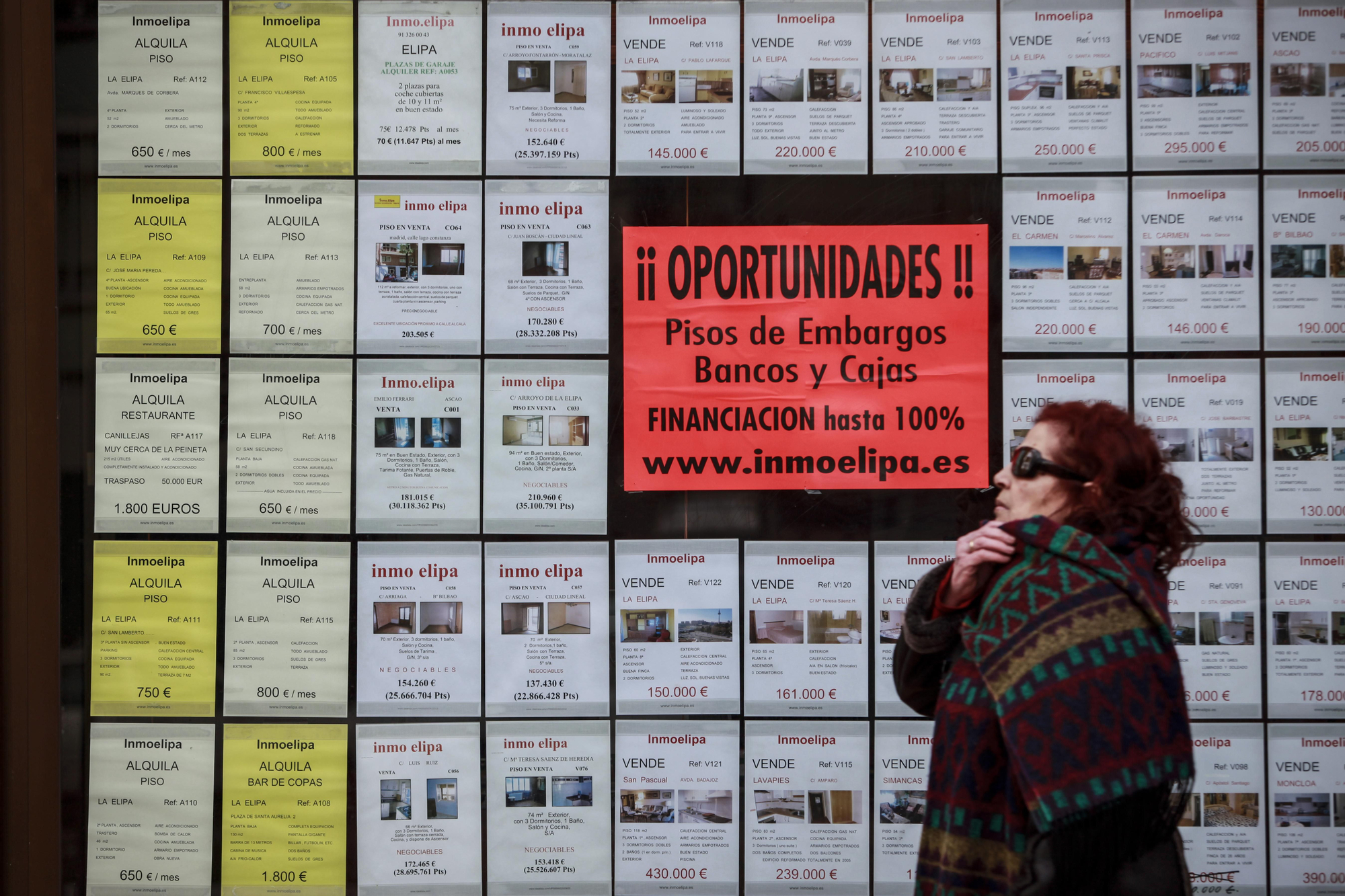 El escaparate de una inmobiliaria anunciando pisos procedentes de embargos en el barrio de La Elipa, en 2011