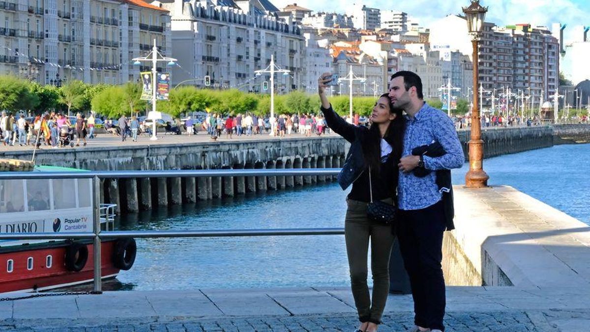 Dos turistas se hacen un selfie en el paseo marítimo de Santander.