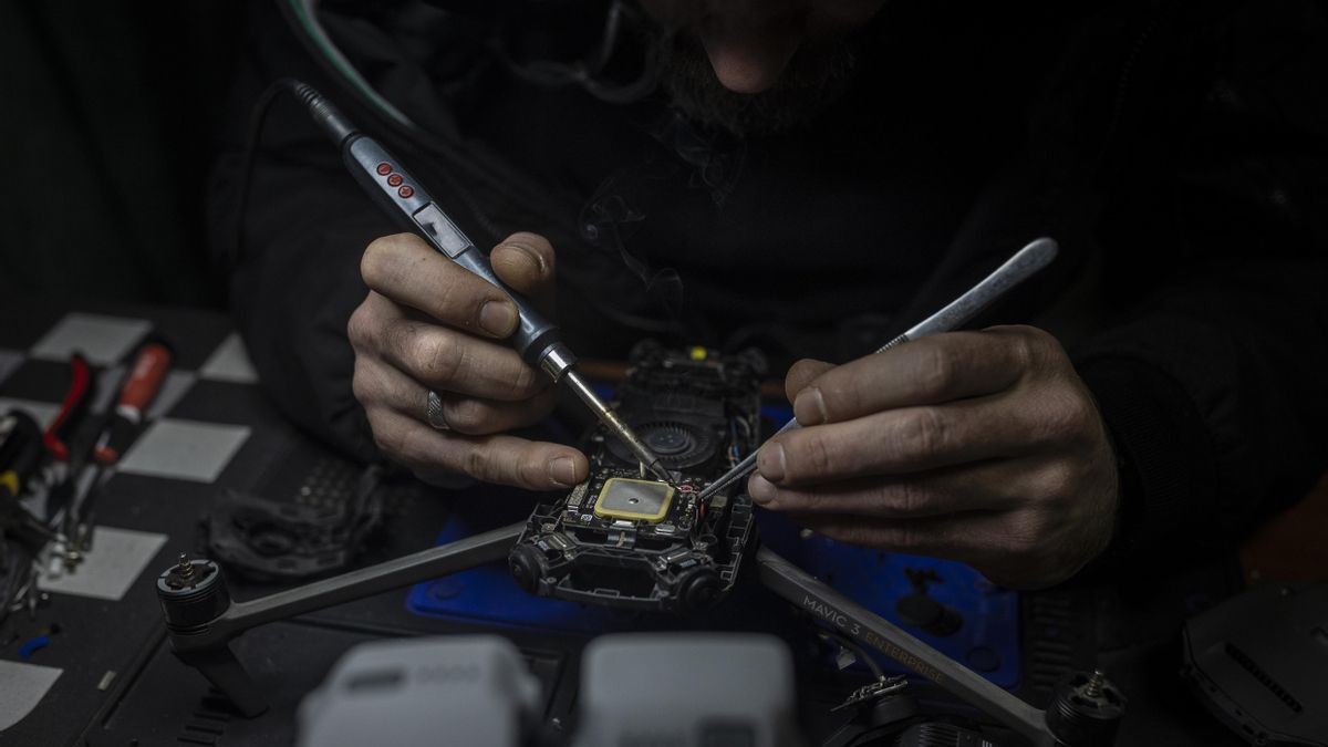 Un técnico militar modifica un dron para convertirlo en un arma de guerra.