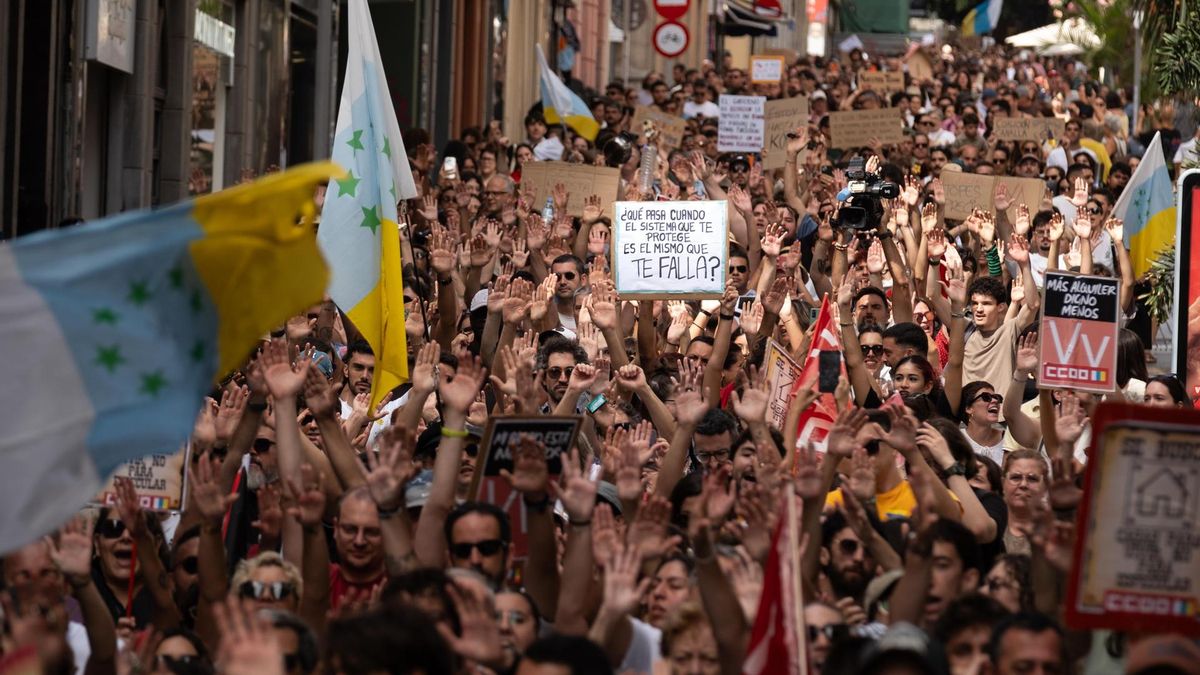 Miles de personas alzan las manos en una calle de Santa Cruz de Tenerife para protestar por el precio de la vivienda.