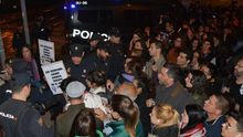 Manifestantes de la concentración feminista intentan atravesar las vías del tren, bloqueadas por la Policía Nacional.