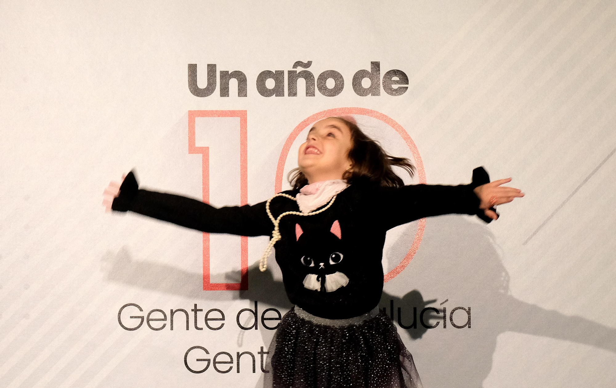 Una niña pasando por delante del photocall