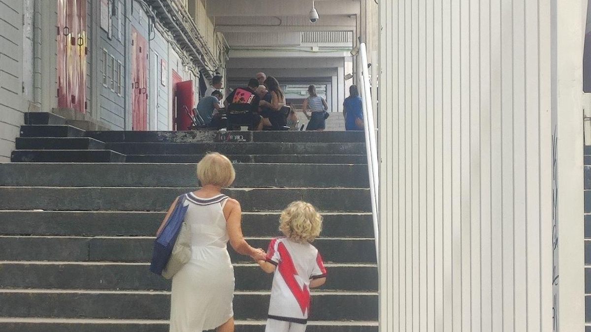 Una abuela y su nieto acuden a la mesa improvisada para la renovación de abonos en el exterior del Estadio de Vallecas.