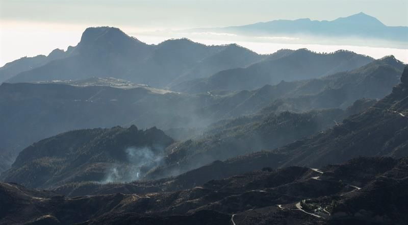 Zonas afectadas por el fuego del incendio forestal, vistas desde la cruz de Tejeda, con el Teide (Tenerife) al fondo.