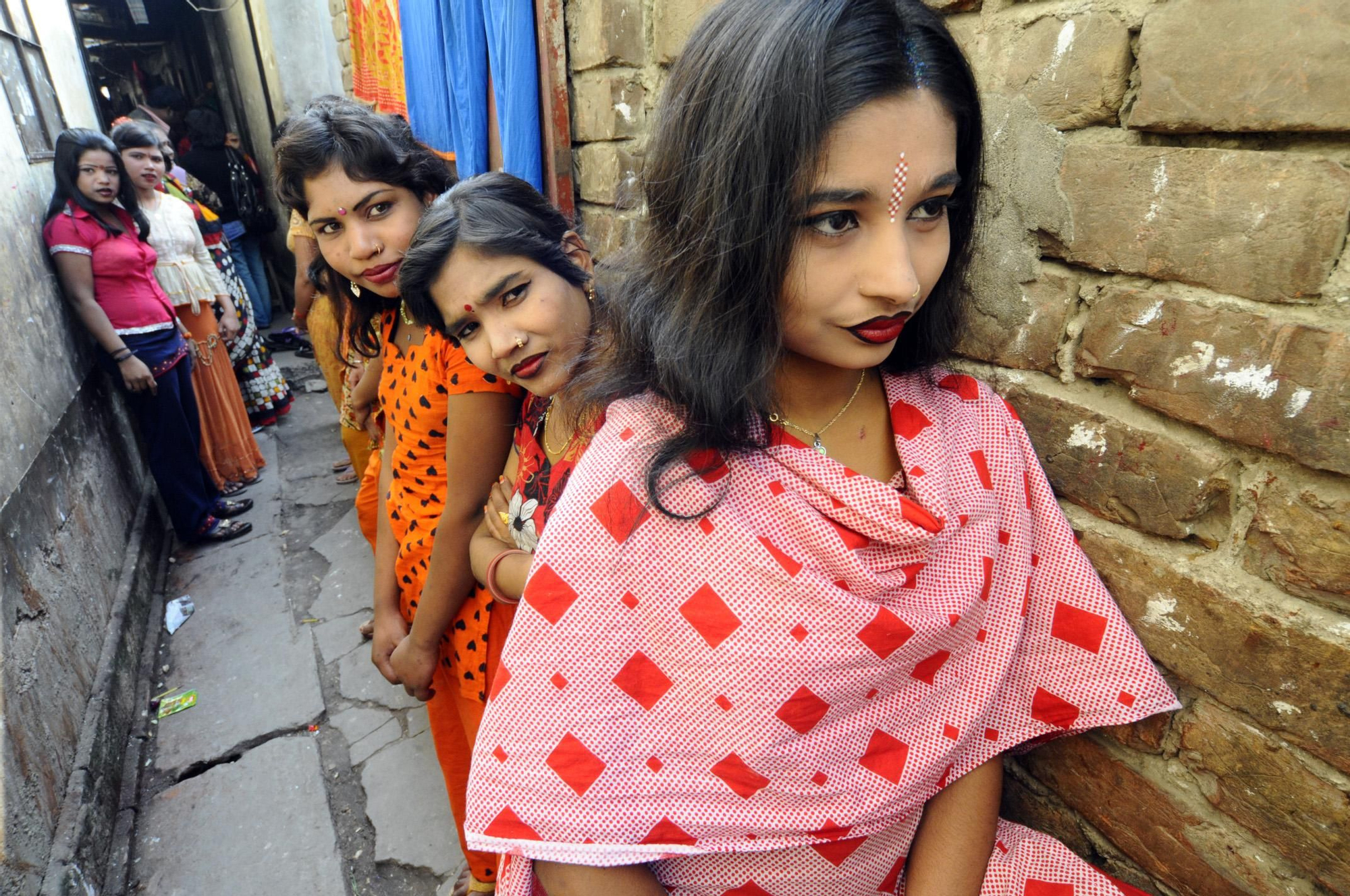 Trabajadoras del sexo en un callejón de Faridpur, a unos 130 kilómetros de la capital de Bangladesh, Dacca, esperan la llegada de clientes. / Zigor Aldama.