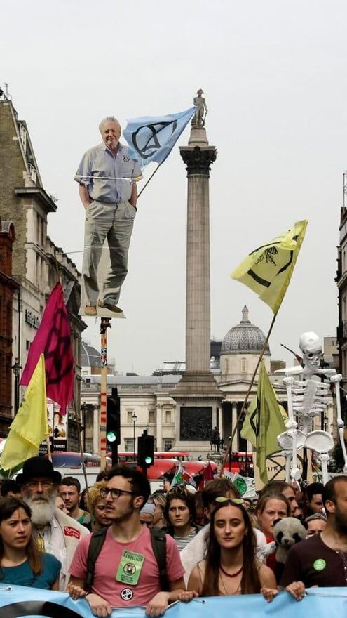 A la derecha: un recorte con una fotografía suya es levantada mientras manifestantes marchan hacia el Parlamento en Londres, el martes 23 de abril de 2019, durante una protesta climática. El grupo de protesta no violenta Extinction Rebellion buscaba negociar con el gobierno para dar prioridad máxima al freno del cambio climático. Foto: Matt Dunham/Archivo AP