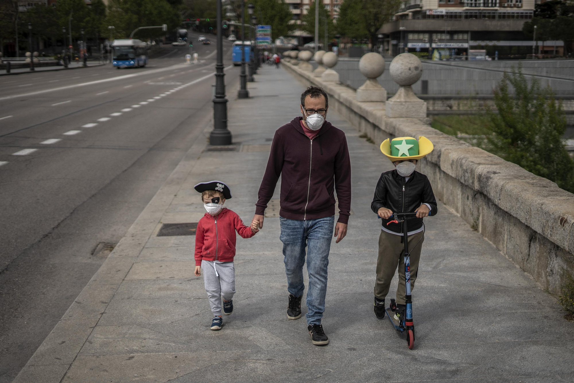 Padre e hijos disfrazados con mascarillas pasean por Madrid