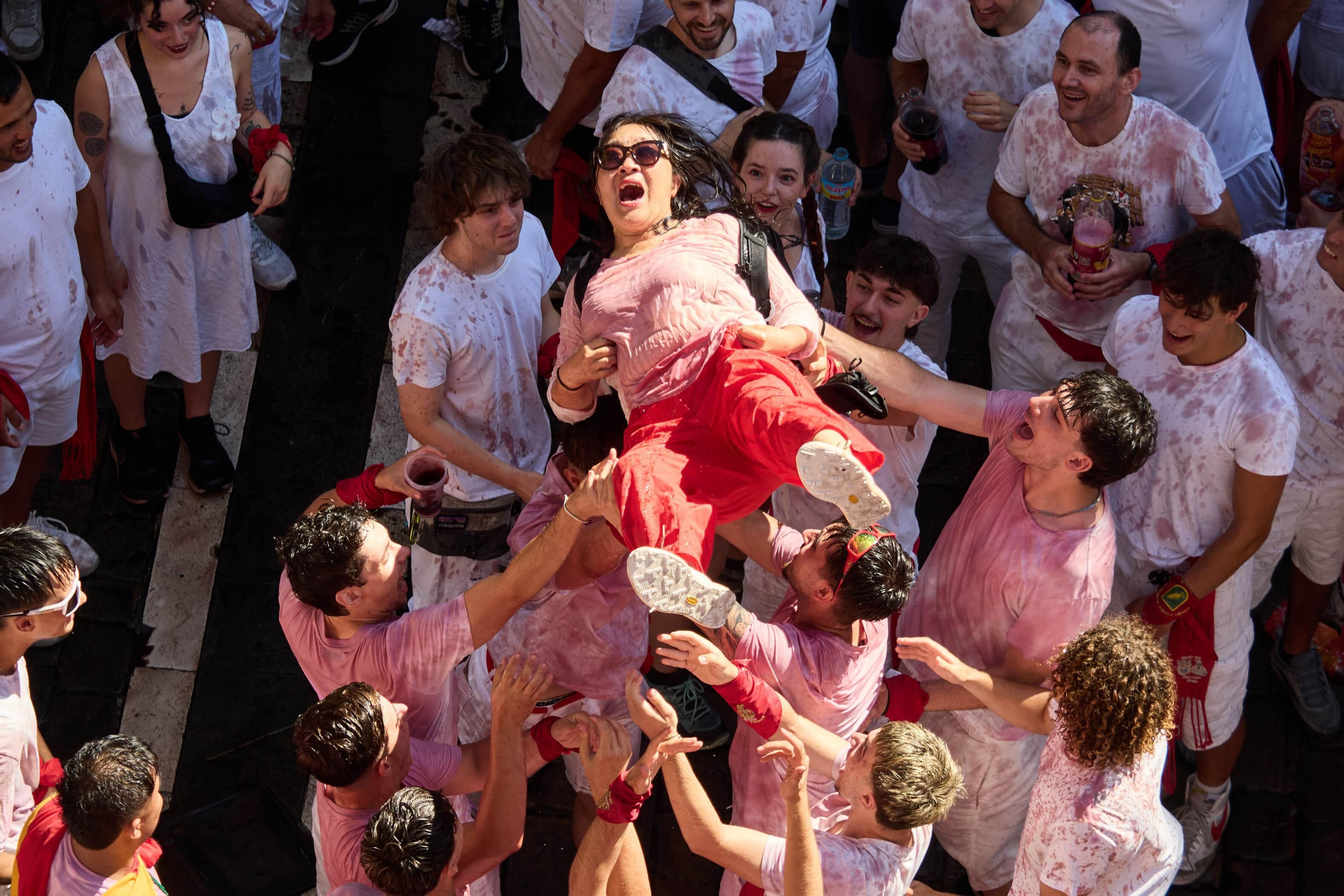 Grupos de asistentes comparten bebidas y momentos de ocio en la Plaza del Ayuntamiento, uno de los principales puntos de encuentro de San Fermín
