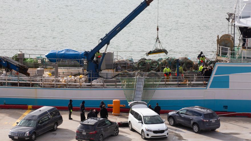 Operarios bajan con la ayuda de una grúa a uno de las personas fallecidas en el naufragio del buque gallego, a su llegada al Puerto de San Juan de Terranova, a 19 de febrero de 2022, en San Juan, Terranova (Canadá).