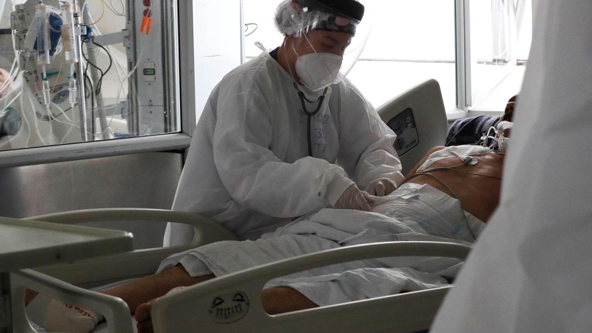 Una empleada de la salud atiende a un paciente en una unidad de cuidados intensivos para enfermos de covid-19 en el Hospital El Tunal en Bogotá (Colombia). EFE/Carlos Ortega/Archivo