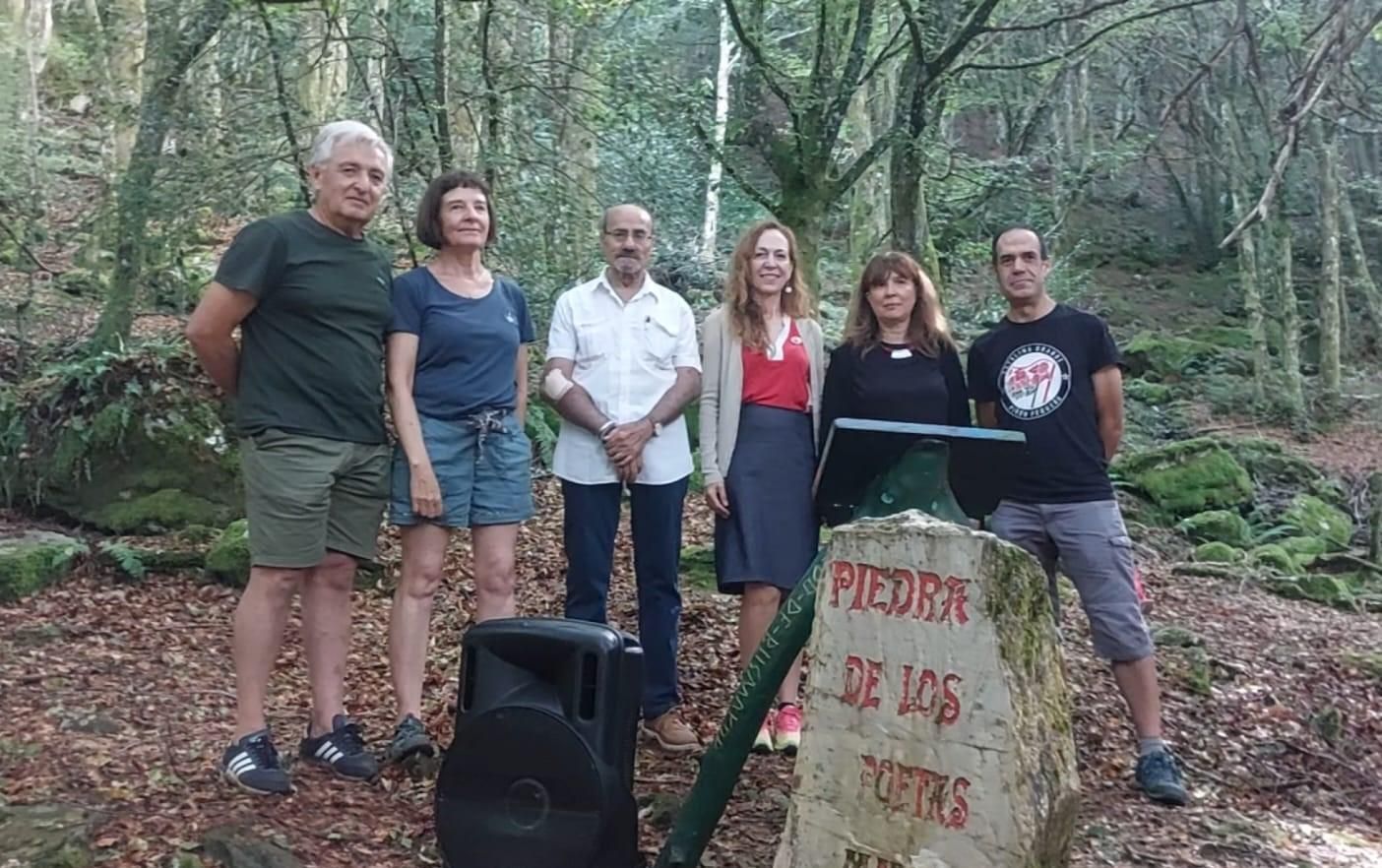 Los participantes en Versos en el Hayedo de 2026, en torno a la 'Piedra de los Poetas'.