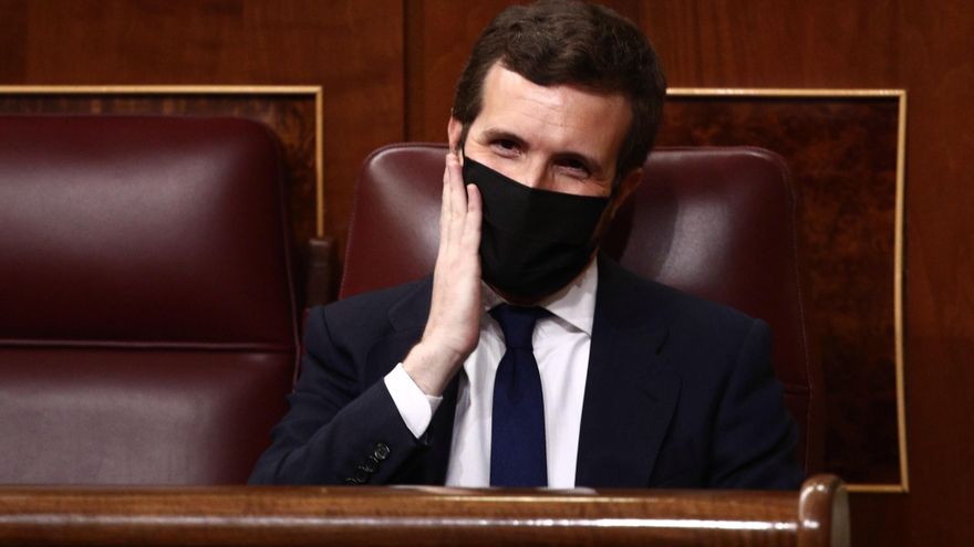 El líder del PP, Pablo Casado, hace un gesto en su cara durante la primera sesión de control al Gobierno de 2021 celebrada en el Congreso