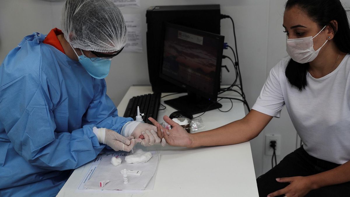 Personal de salud hace una prueba de coronavirus a través de muestras de sangre. EFE/ Antonio Lacerda/Archivo